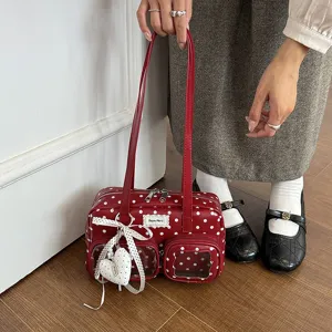 Red polka dot bowling bag detail showing front transparent pockets and heart pendant.