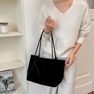 Detailed view of the black canvas tote bag, featuring slim double straps and minimalist retro design.