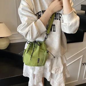 Green nylon drawstring bucket crossbody bag with mesh side pocket, casual daily wear.