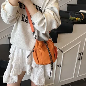 Orange nylon drawstring bucket crossbody bag, casual sporty style for daily outdoor wear.