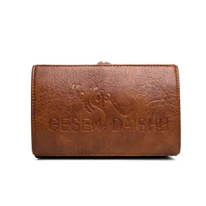 Vue de détail de la texture du sac à main en cuir marron vintage, logo de marque en relief.