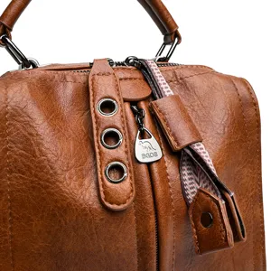 Vue détaillée de sac à main vintage marron, texture cuir de qualité et quinzalerie métal.