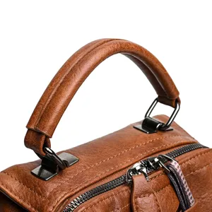 Gros plan sur la poignée de sac à main en cuir vintage marron et détail de fermeture éclair.