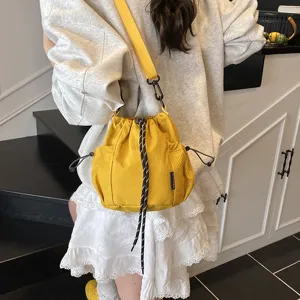 Casual nylon drawstring bucket bag with shoulder strap for daily outdoor sports and fashion use.