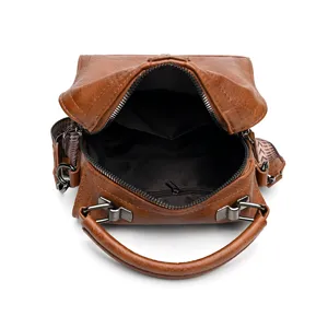 Vue détaillée du sac à main rétro marron avec poche intérieure zippée et poignée en métal.