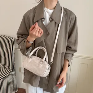 Detail der Schultertasche mit Flechtmuster, stilvolle kleine Handtasche in Beige.
