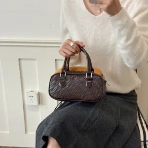 Detailansicht der gewebten Lederhandtasche, die exquisite Textur und praktische Griffe zeigt.