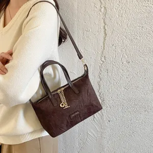 Classic brown suede shoulder bag for women, retro casual handbag with metal chain detail.