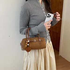 Retro braune Wildleder Boston Handtasche für Damen, lässige Umhängetasche mit hübschen Anhängern.