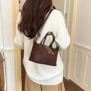 Classic brown suede handbag for women, elegant retro crossbody bag with chain detail.