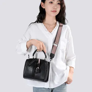 Vue détaillée du sac à bandoulière élégant en cuir noir avec large sangle ethnique sur mannequin.