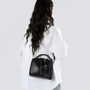 Vue détaillée du sac à bandoulière rétro noir pour femme porté par le modèle, belle texture.