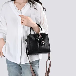 Vue détaillée du sac à bandoulière rétro noir avec une sangle à motif élégante et une poignée.