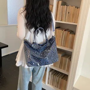 Vista dettagliata della borsa tote elegante con stampa leopardata blu e tracolla capiente.
