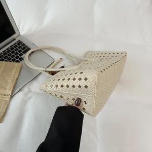 Detailed view of a beige woven PU leather tote bag, featuring a stylish hollow-out design.
