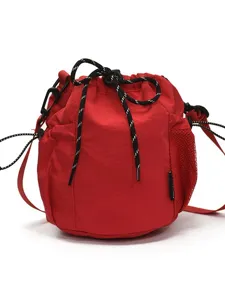 Red nylon bucket bag with drawstring, casual outdoor sports crossbody bag with side mesh pocket.