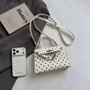 Detailed view of women's trendy polka dot Kelly shoulder bag with chic handle and strap.