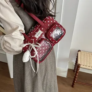 Red polka dot shoulder bowling bag detail view with transparent front pockets and pearl ribbon charm.
