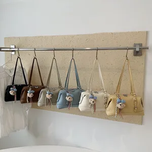 Detailed view of multiple color vintage shoulder bags hanging neatly on display showcase.