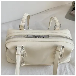 Cream vintage underarm shoulder bag detail showing dual metallic zippers and handles.