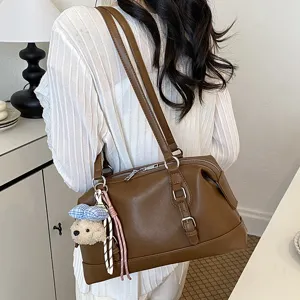 Brown retro large capacity shoulder bag for women, stylish commuting underarm bag with charm.