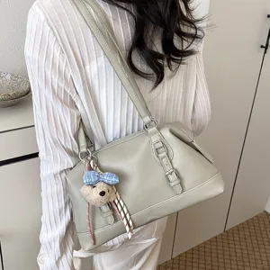 Detailed view of the vintage grey shoulder bag with cute bear charm and retro belt buckle.