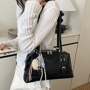Detailed view of black vintage shoulder bag with cute charms and double handles for women.