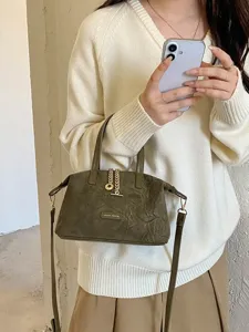 Stylish minimalist suede top-handle crossbody bag with metal chain pendant for women everyday wear.