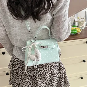 Mint green polka dot Kelly handbag with top handle, shoulder strap and cute heart charm.