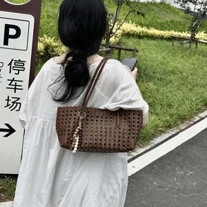 Brown woven leather tote bag detail, stylish commuter shoulder bag with beaded charm.