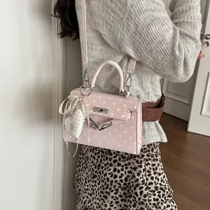 Pink polka dot handbag with pearl heart pendant, stylish top handle shoulder bag for women.