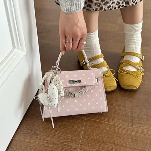 Pink polka dot Kelly handbag with pearl heart charm, stylish top handle shoulder bag for women.