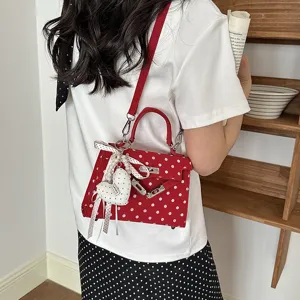 Red polka dot mini Kelly shoulder bag, chic crossbody handbag with cute heart pendant charm.