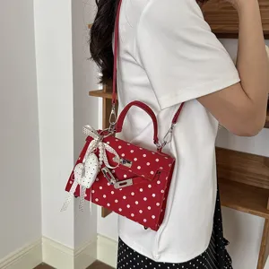 Red polka dot crossbody shoulder bag with Kelly design, metal lock and cute heart charm.