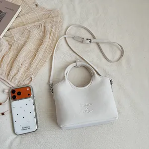 Minimalistische weiße Beuteltasche mit Henkel und Schulterriemen für Damen im Alltag.