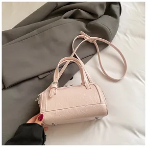 Pink patent leather Boston bag for women, stylish pillow handbag with crossbody strap.