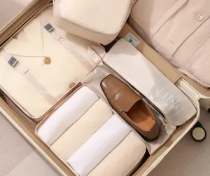 Detail of beige travel packing cubes in suitcase with mesh windows for neat storage.