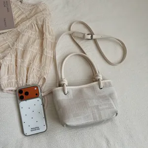 Detailansicht der cremefarbenen Canvas Eimer Tasche mit Schultergurt, minimalistischer Stil.