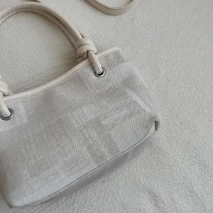 Beigefarbene Leinentasche mit Lederbesatz, stilvolles Henkeltasche-Design für Damen.