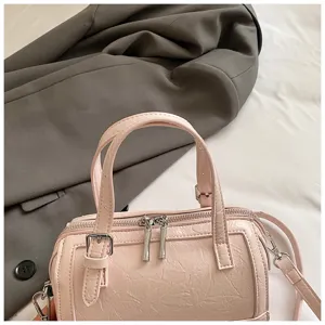 Pink crinkled leather Boston bag detail, stylish women pillow handbag with top handles and strap.