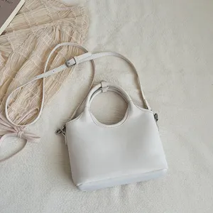 Minimalistische weiße Eimer Tasche Detail mit Griff und verstellbarem Riemen für Damen.