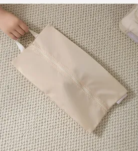 Detail van beige reizen opbergtas, ritssluiting met handvat, draagbare stoffen organizer tas.
