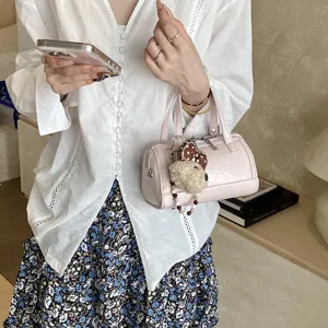 Pink PU leather Boston pillow bag with cute plush dog pendant, stylish crossbody hand bag design.