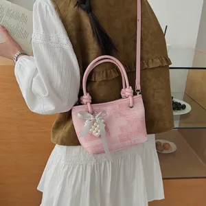 Detailansicht der rosa karierten EimerTasche mit Perlenherz-Anhänger und schicker Schleife.