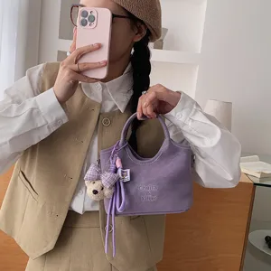 Chicke violette Beuteltasche mit süßem Bärenanhänger, stilvolle minimalistische Damentasche.