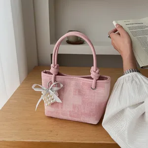 Schicke pinkfarbene Tweed-Eimer-Tasche mit geflochtenem Griff und Perlen-Herz-Schleife.