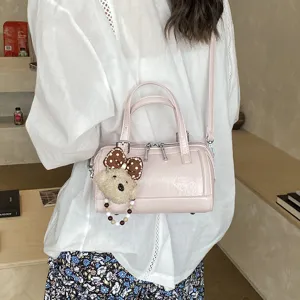 Pink Boston shoulder bag detail view, chic PU leather handbag with cute bear charm for women.
