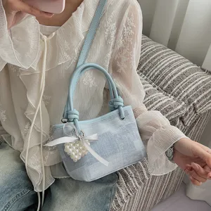 Detailaufnahme der hellblauen EimerTasche mit schickem Perlen-Herz-Anhänger und Schleife.