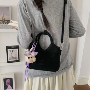 Schicke schwarze Beuteltasche mit Bärenanhänger, vielseitige Umhängetasche für Damen.
