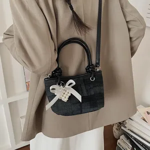 Detailansicht der trendigen schwarzen Denim-Eimertasche mit Perlen Schleife Umhängetasche.